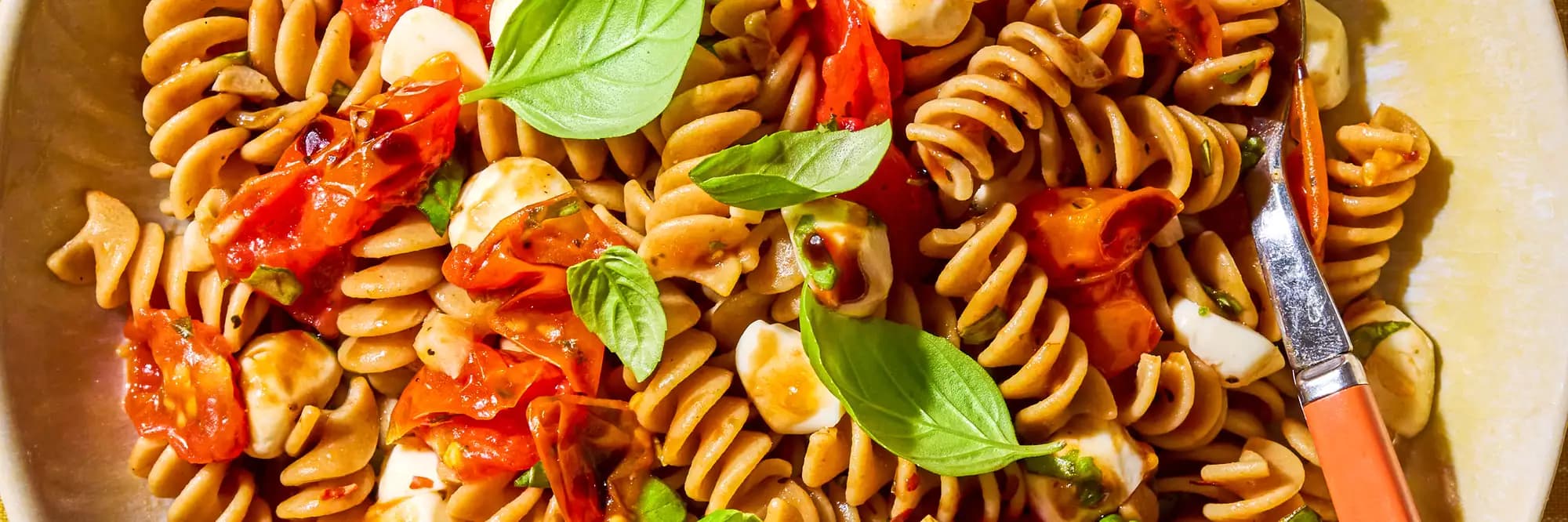 Melting Cherry Tomato & Mozzarella Pasta in a bowl up-close overhead